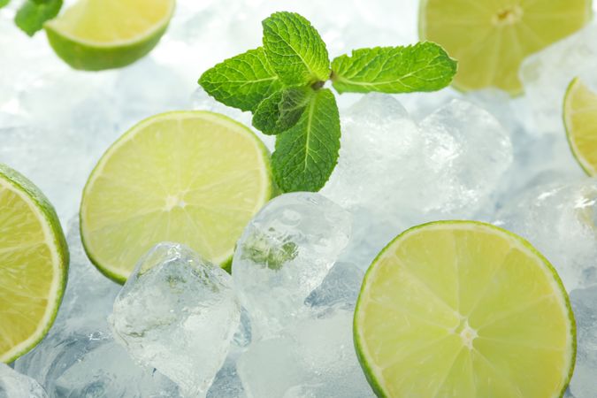 Close up of pile of ice with lime halves and mint
