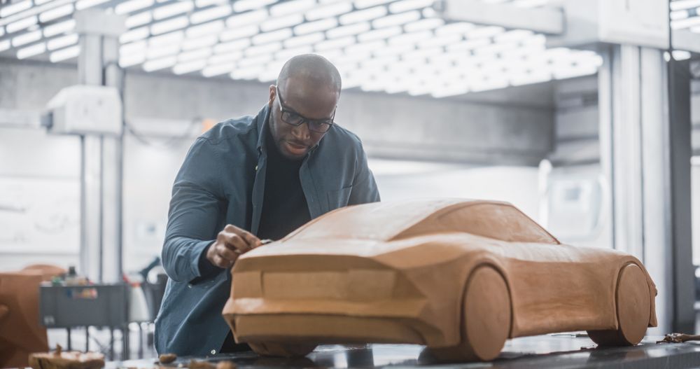 Designer Working on a Prototype, Sculpting the Rear of a Clay 3D Model of a Sport Coupe