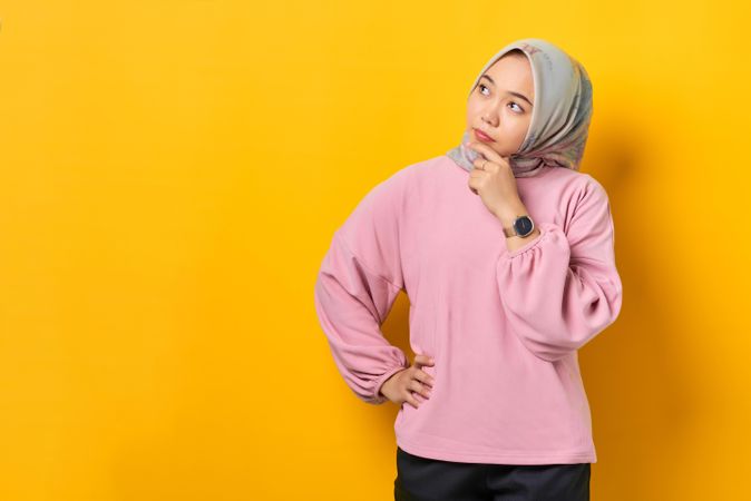 Muslim woman in headscarf contemplating something and looking to the side