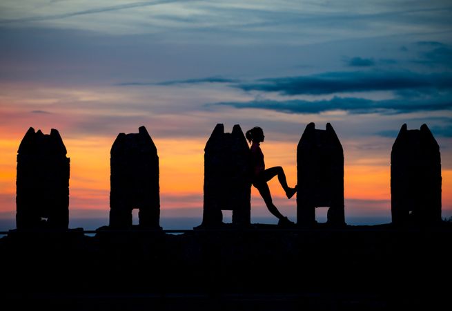 Silhouette of person between stone sculptures in sunset