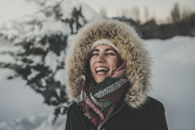 Young woman laughing on snowy background