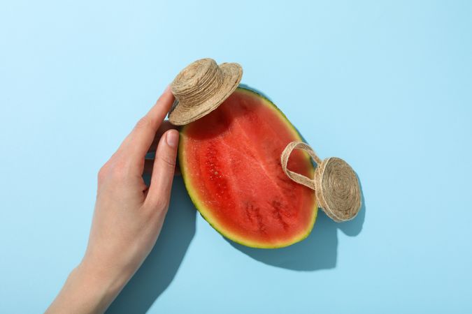 A piece of watermelon with a hat on a blue background