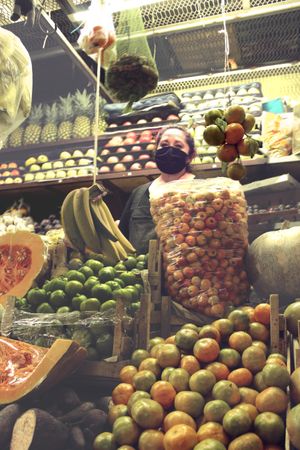 Woman with facemask standing at fruit stand