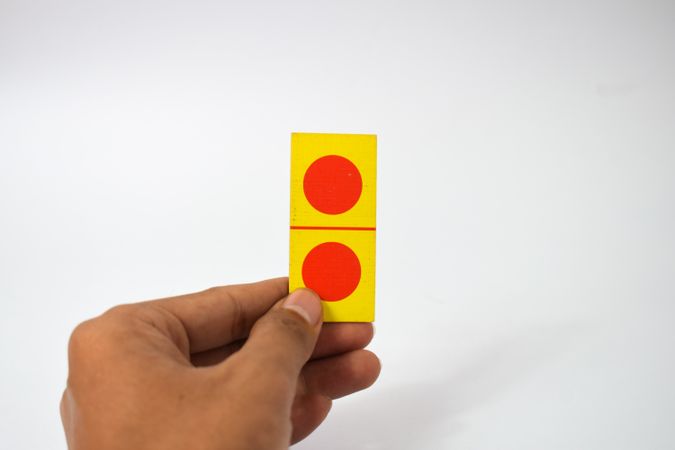 Person holding one domino card