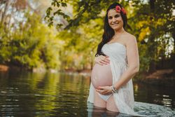 Pregnant woman standing in lake water
