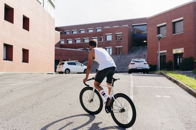 Man riding bike next to buildings