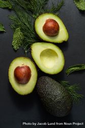 Close up of avocados cut into halves on a dark background 41plD5