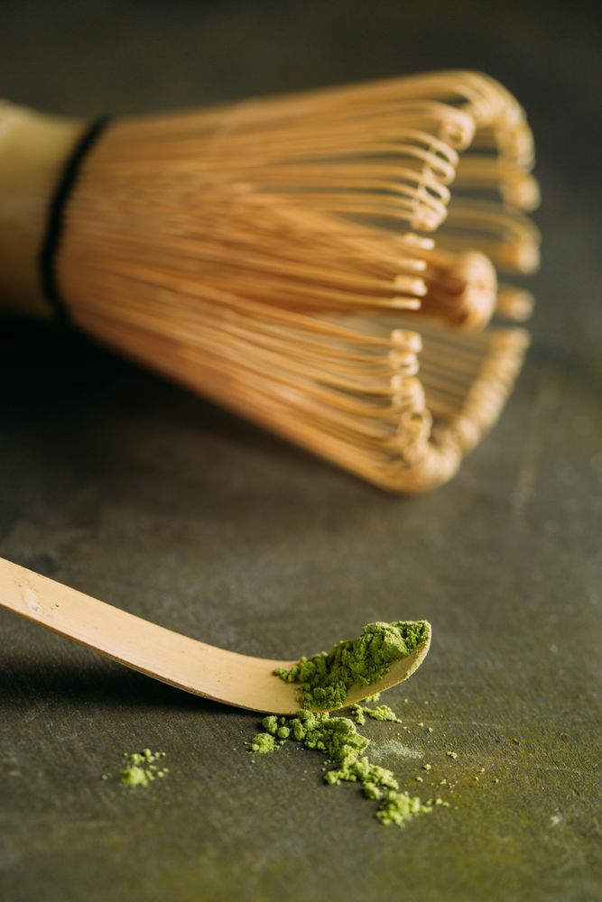 Green matcha tea powder and bamboo whisk