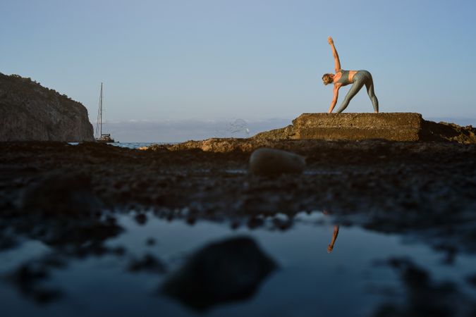 Female doing stretching exercise on seashore