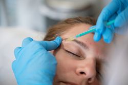 Woman receiving facial injection during rejuvenation treatment in clinic