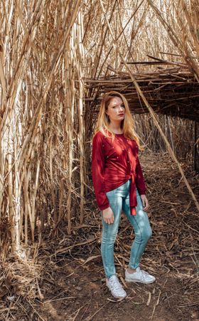 Woman standing on footpath through reed growth