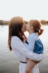 Mother and daughter standing near water