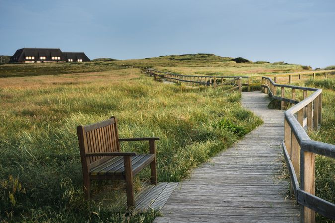 Wooden pathway and seating  surrounded by grass