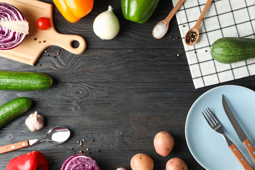 Kitchen supplies, vegetables and spices on wooden background, copy space