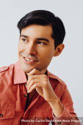 Headshot of happy Hispanic male looking away from camera in grey studio, vertical bDxMpb