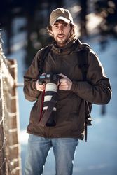 Man with camera in winter forest