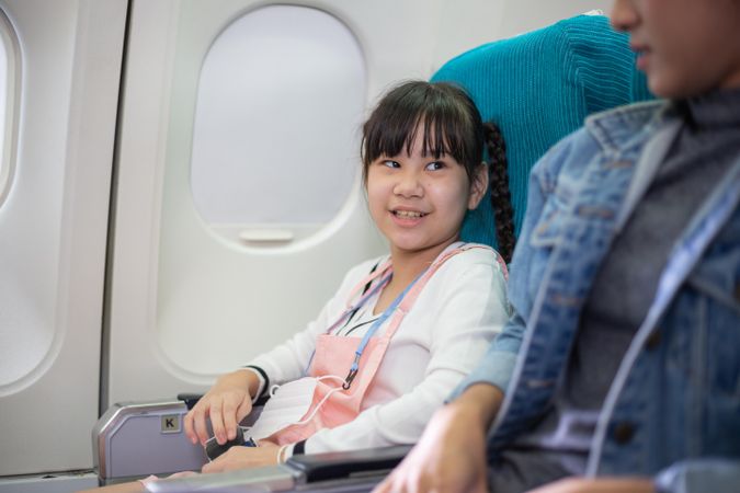 Female child sitting at window seat in airplane