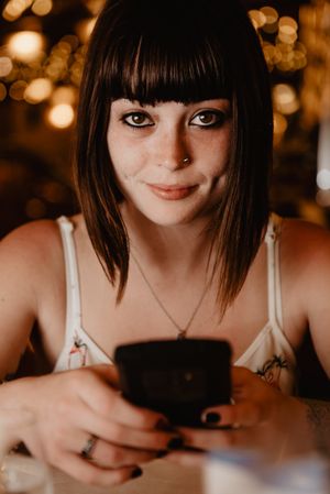 Smiling woman using smartphone in restaurant