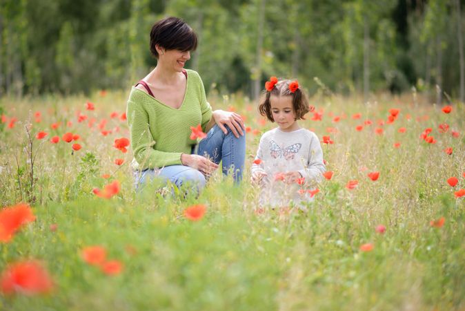 Mother and daughter picking flowers in field