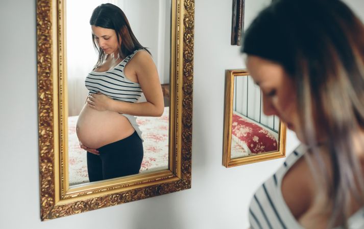 Pregnant woman looking at her belly