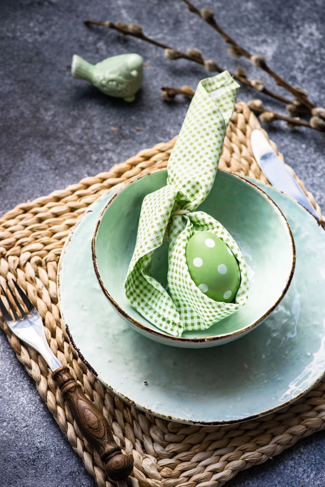 Easter holiday table setting with pastel egg wrapped in bunny napkin