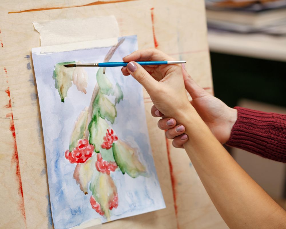 Teacher showing student a painting technique