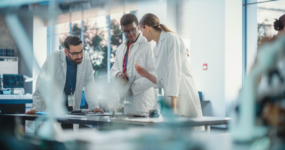 Team of Professionals Discuss Manufacturing and Using Laptop Computer