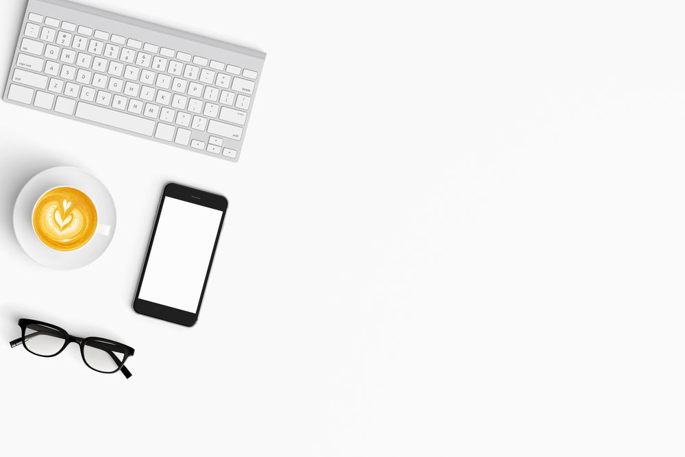 Modern workspace with coffee cup, smartphone, paper, tablet and notebook copy space