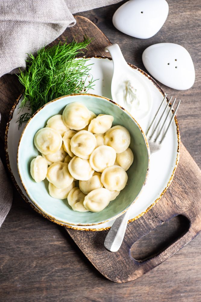 Top view of bowl of hearty Russian dumplings with salt and pepper shakers