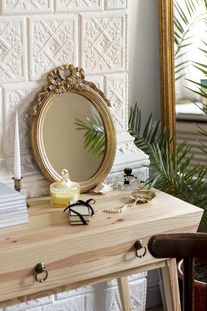 Mirror and perfume on wooden table