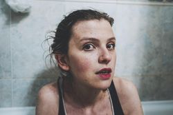 Portrait of young woman with red lipsticks against tile wall
