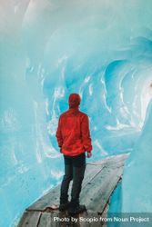 Man in red hoodie standing in ice cave beweP5