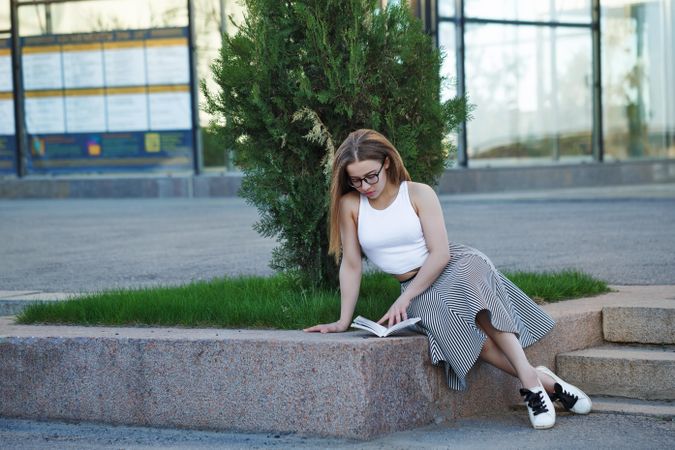 Woman in glasses reading outside