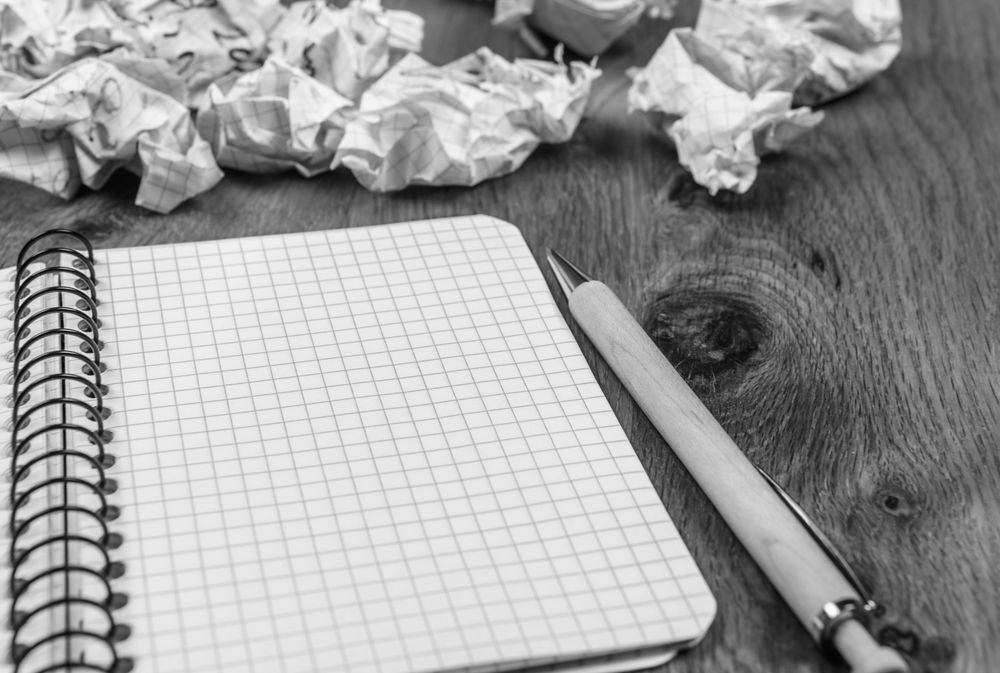 Spiral notebook and crumpled drafts