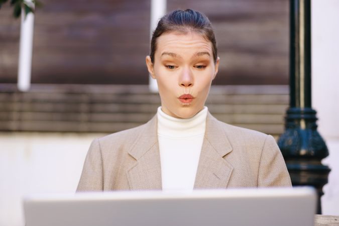 A Surprised Businesswoman is Working Deliberately on Her Laptop While in an Outdoor Setting