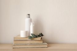 Beauty creams atop pile of books