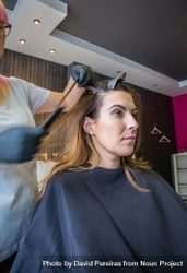 Hairdresser taking strands of client's hair to dye 0yKYG4