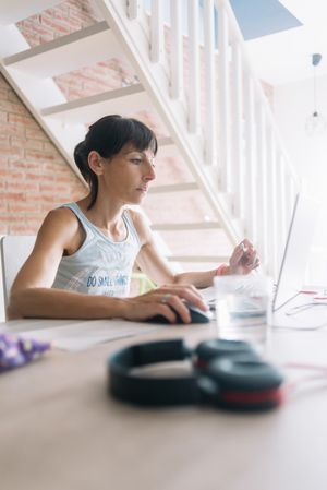 Woman working at laptop at bright home desk