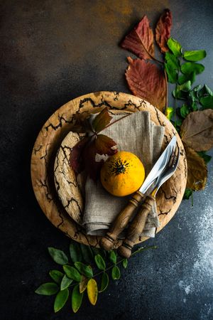 Top view of rustic autumnal table setting with mini squash and leaves