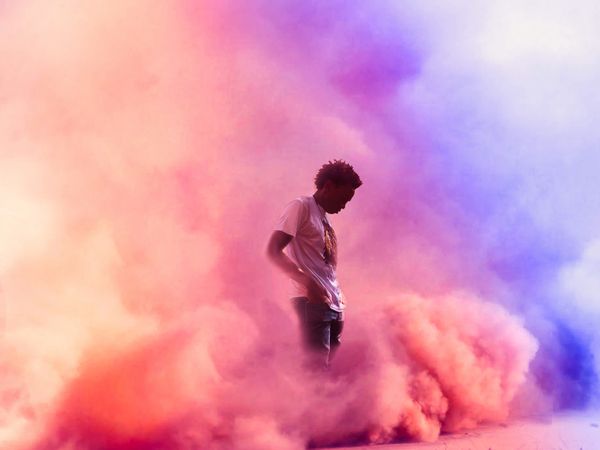 Man standing in pink smoke