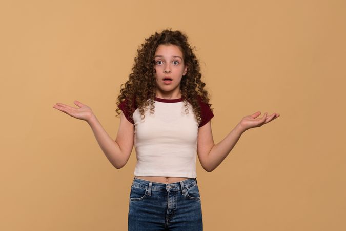 Young girl with arms open, showing confused expression