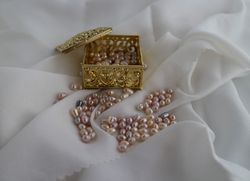 an open jewelry gold box with freshwater pearls