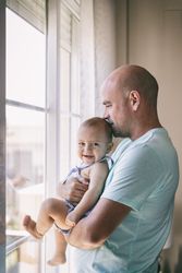 Father with baby looking out window