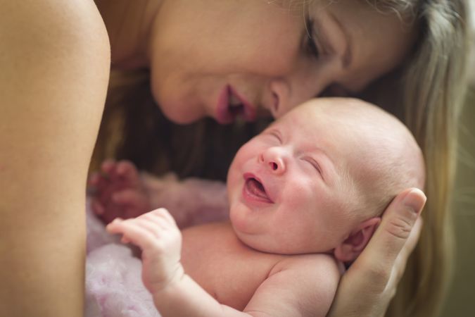 Young Mother Holding Her Cute Newborn Baby Girl