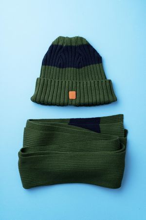 Green beanie ans scarf on blue background