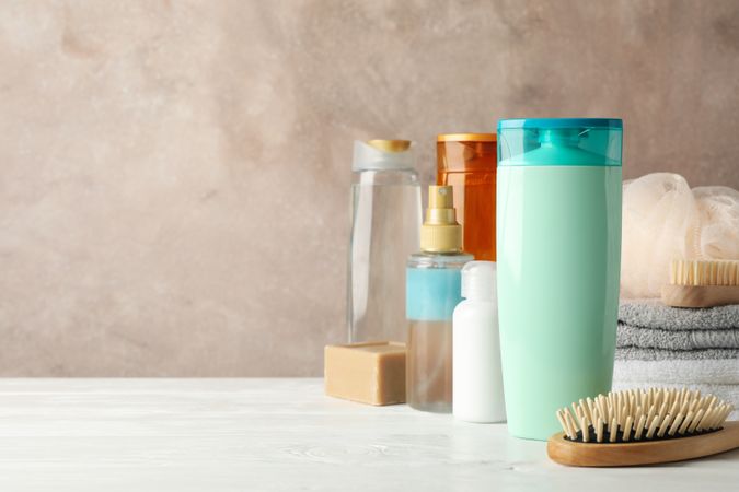 Composition with hair care products on wooden table. Blank space for label