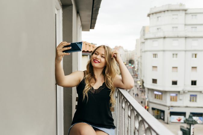 Young smiling female taking selfie on terrace