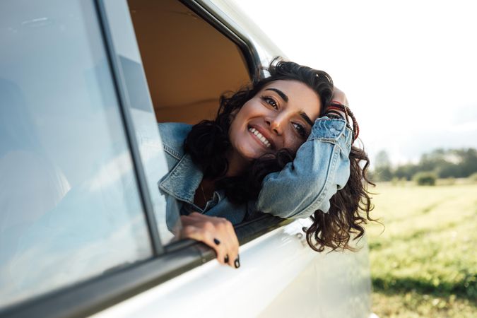 Smiling female looks out of van window