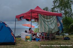 Beach tent set up on grass near the water 4A7YR0