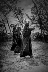 Three Muslim women walking towards the beach, b&w